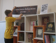 библиотекарь на один день оформляет книжную выставку в универсальном читальном зале